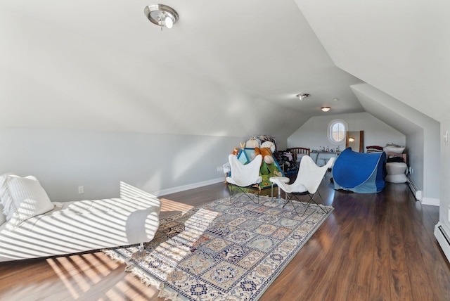 interior space featuring vaulted ceiling, dark hardwood / wood-style flooring, and a baseboard heating unit