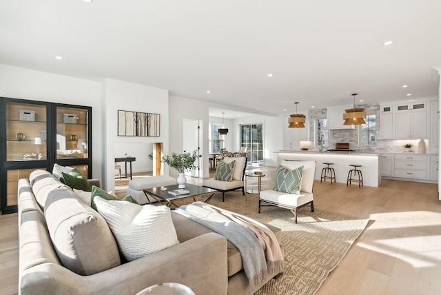 living room featuring sink and light hardwood / wood-style floors