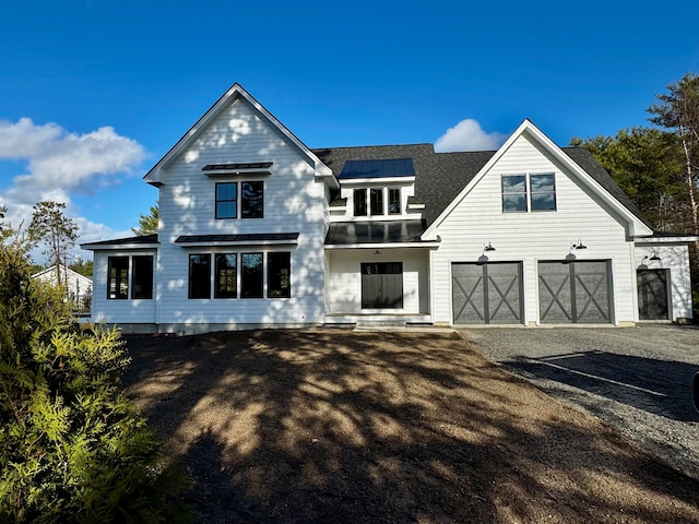 view of front of home featuring solar panels and a garage