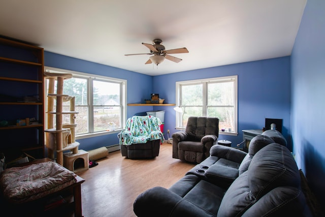 living room featuring hardwood / wood-style floors, a baseboard heating unit, and ceiling fan