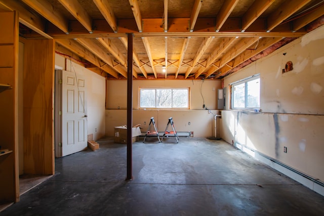 basement with a wealth of natural light and a baseboard heating unit