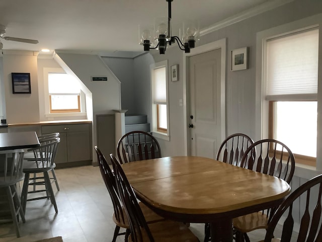 dining area featuring crown molding and ceiling fan with notable chandelier