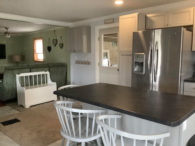 kitchen featuring ornamental molding, stainless steel refrigerator with ice dispenser, white cabinets, and ceiling fan