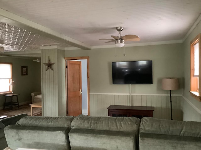 living room with ceiling fan and ornamental molding