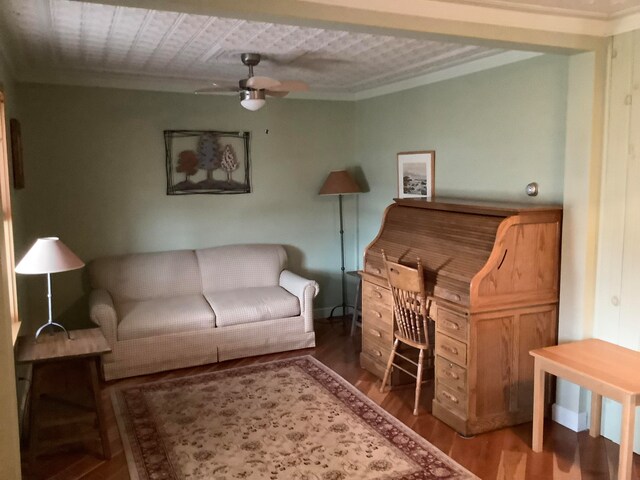 living room with ornamental molding, hardwood / wood-style flooring, and ceiling fan