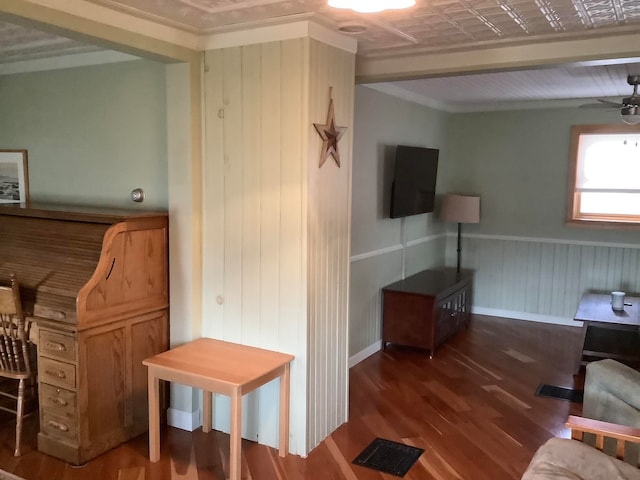 living room featuring crown molding, beam ceiling, hardwood / wood-style flooring, and ceiling fan