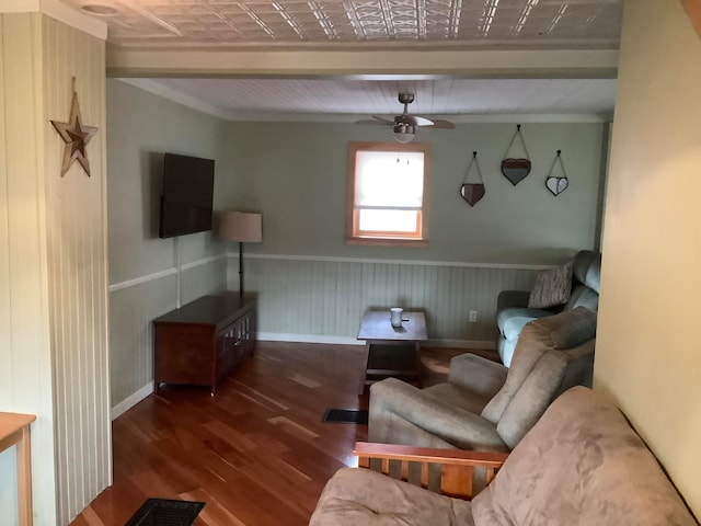 living room with beamed ceiling, ornamental molding, hardwood / wood-style flooring, and ceiling fan