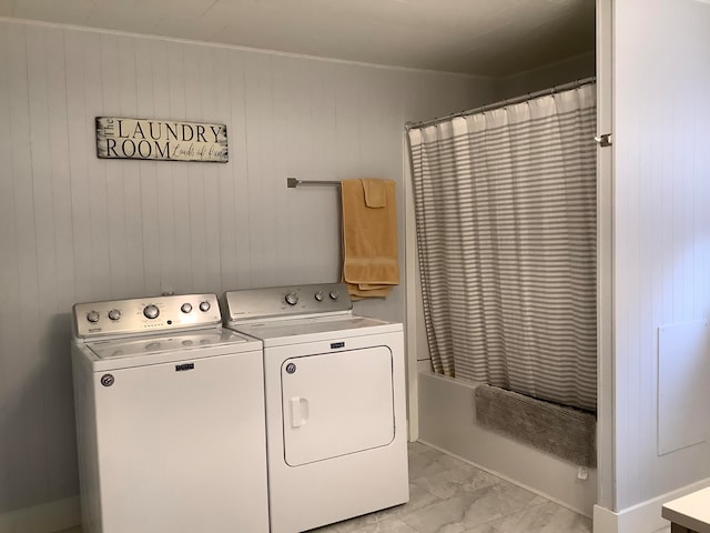 clothes washing area featuring wood walls and separate washer and dryer