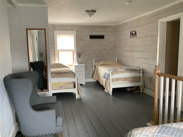 bedroom featuring hardwood / wood-style flooring and wooden walls