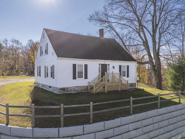 cape cod home featuring a front lawn