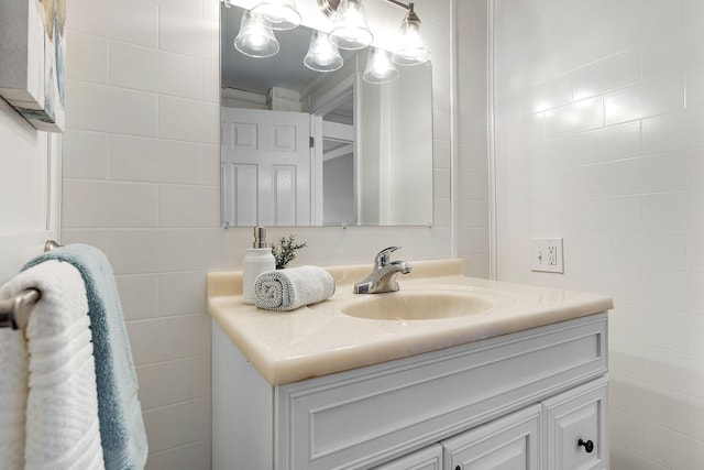 bathroom featuring tile walls, vanity, and crown molding