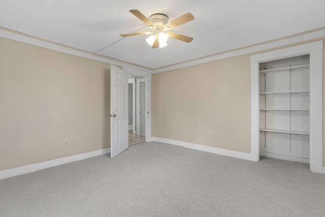 unfurnished bedroom featuring ceiling fan, crown molding, and carpet floors