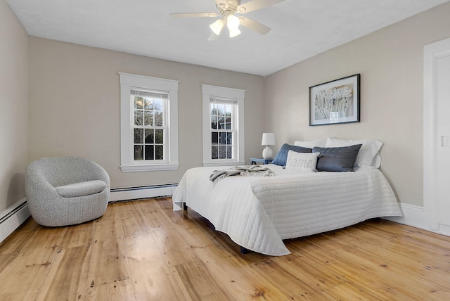 bedroom featuring baseboard heating, hardwood / wood-style floors, and ceiling fan