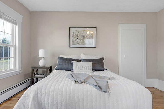 bedroom featuring hardwood / wood-style flooring and a baseboard radiator