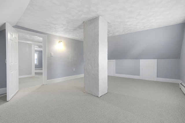 interior space with a textured ceiling, light colored carpet, and vaulted ceiling