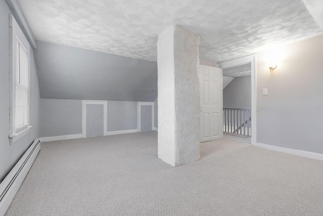 bonus room featuring a textured ceiling, a baseboard radiator, lofted ceiling, and light carpet