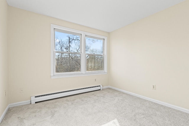 spare room with baseboard heating and light carpet