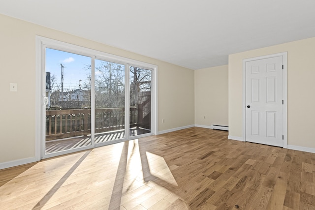 empty room featuring light hardwood / wood-style floors and baseboard heating