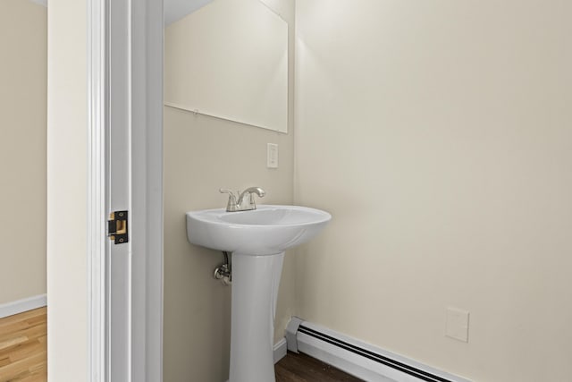 bathroom with hardwood / wood-style flooring and baseboard heating