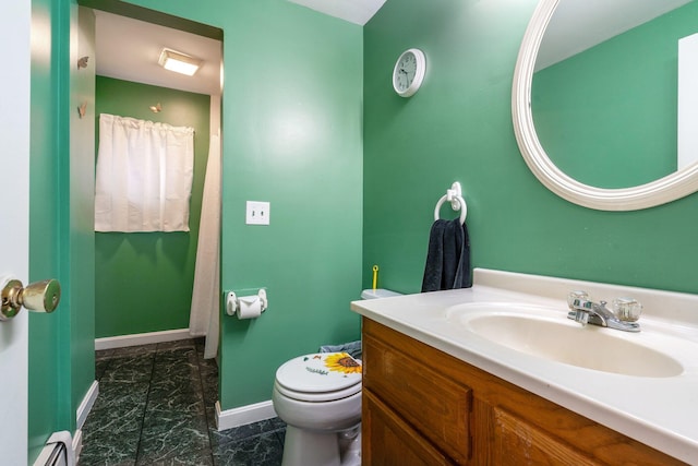 bathroom with toilet, vanity, and a baseboard heating unit