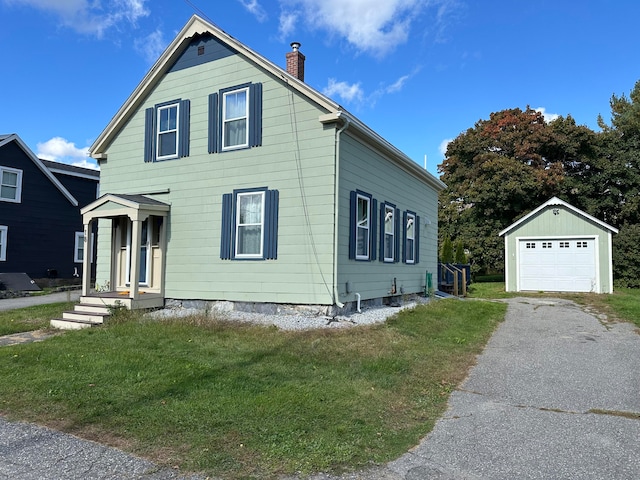 view of front of house featuring a garage, an outdoor structure, and a front lawn