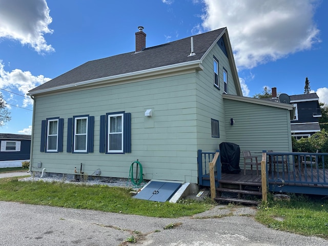 rear view of house featuring a wooden deck