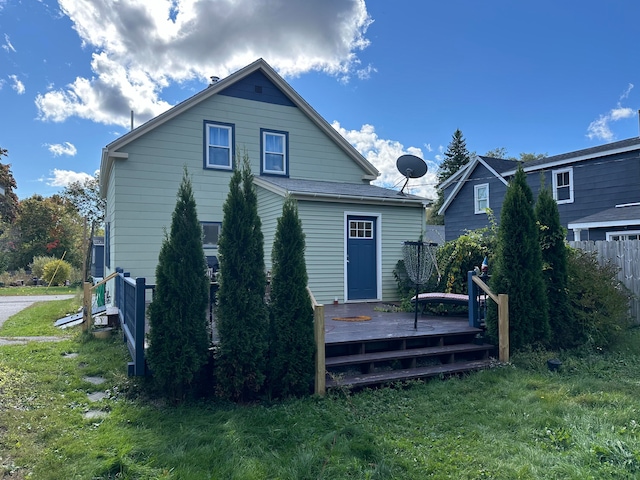 back of property featuring a lawn and a wooden deck