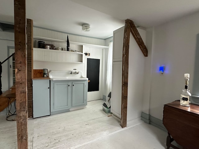 kitchen with gray cabinetry, sink, and light hardwood / wood-style floors