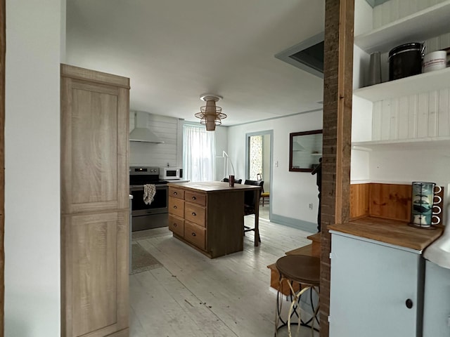 kitchen featuring a kitchen island, electric stove, wall chimney exhaust hood, and light hardwood / wood-style flooring