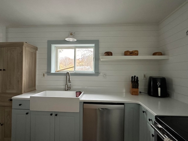 kitchen with white cabinets, wood walls, sink, and dishwasher