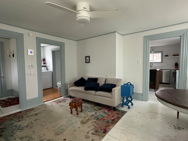 living room with hardwood / wood-style floors, ceiling fan, and washer / dryer