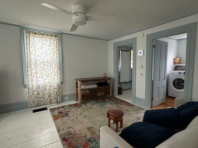 living room with ceiling fan, light wood-type flooring, and washer / clothes dryer