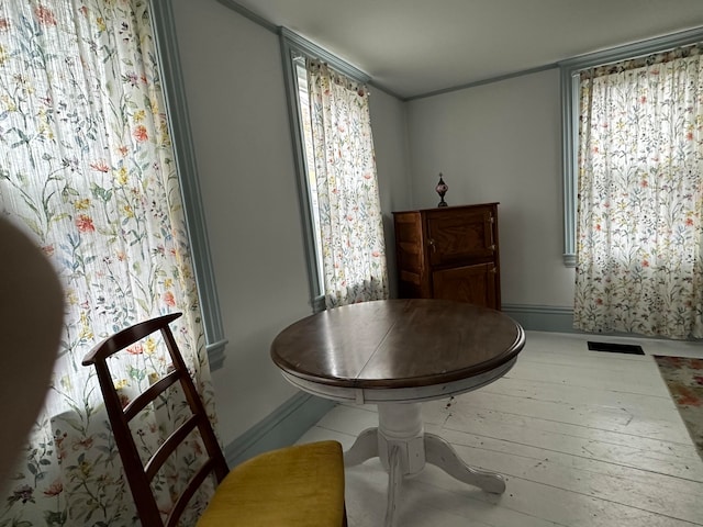 dining area with plenty of natural light and hardwood / wood-style flooring