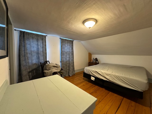 bedroom featuring hardwood / wood-style flooring and vaulted ceiling