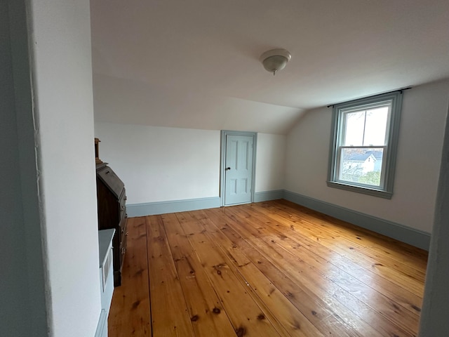 bonus room with light hardwood / wood-style flooring and lofted ceiling