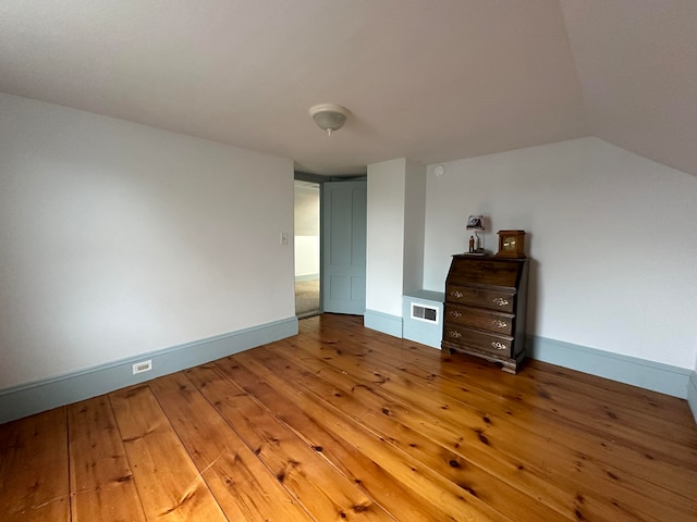 unfurnished bedroom featuring hardwood / wood-style floors and vaulted ceiling