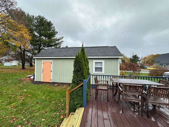 deck with a water view, a lawn, and a shed