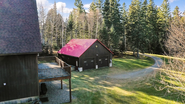 view of yard with a garage, an outdoor structure, and a wooden deck