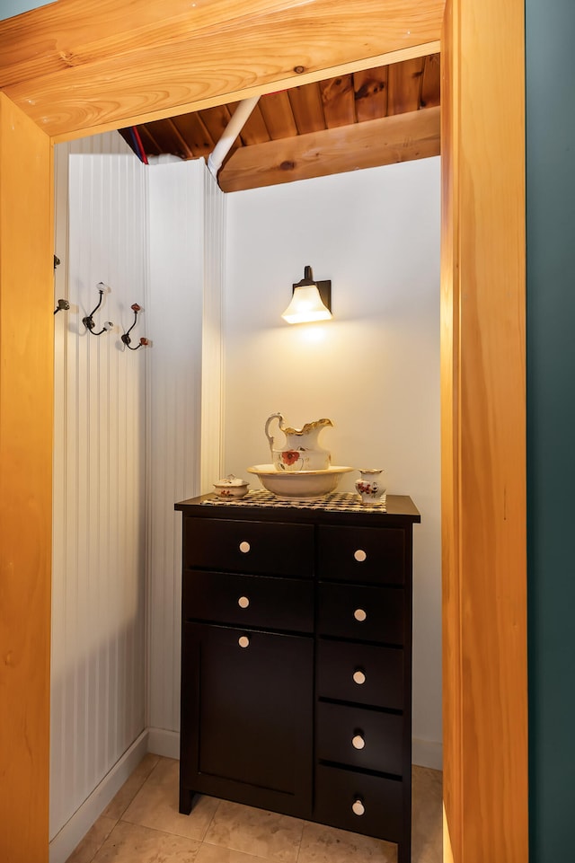 bathroom featuring tile patterned flooring, vanity, and wooden ceiling