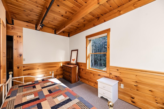 bedroom featuring beamed ceiling, dark carpet, wood ceiling, and wooden walls