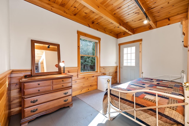 bedroom with wood walls, beam ceiling, and wood ceiling