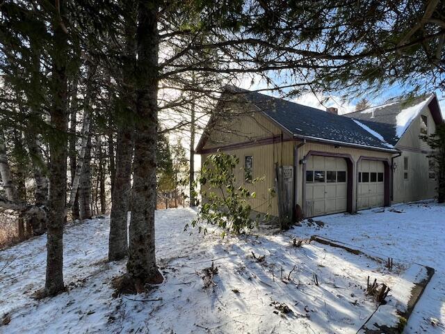 view of snowy exterior with a garage