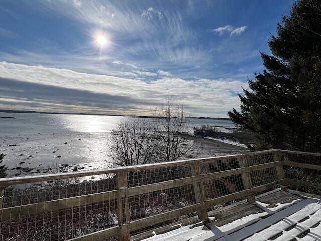 snow covered deck featuring a water view