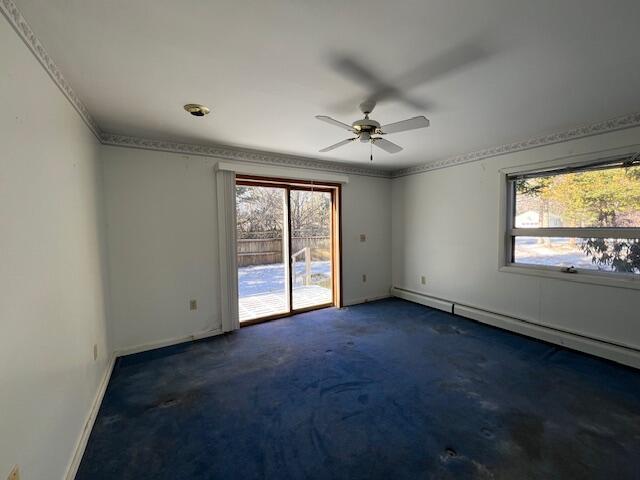 carpeted spare room with a baseboard radiator and ceiling fan