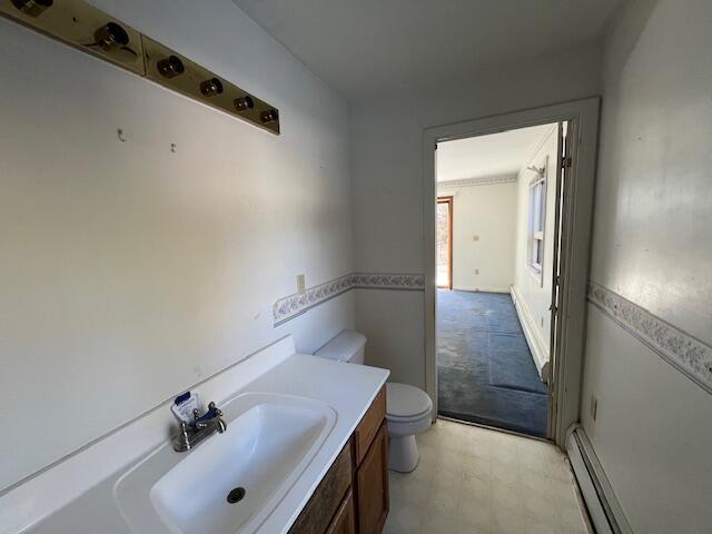 bathroom with baseboard heating, vanity, and toilet