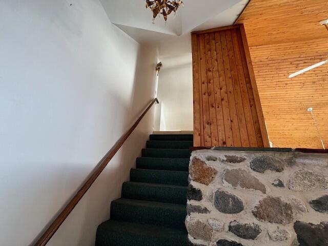 stairs featuring wood walls