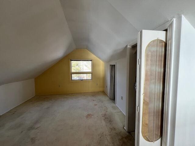 additional living space featuring light carpet and vaulted ceiling