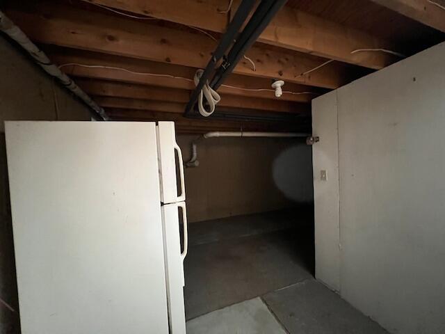 basement with white refrigerator