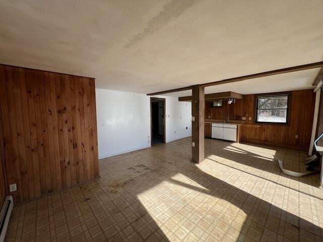 unfurnished living room featuring wooden walls and baseboard heating