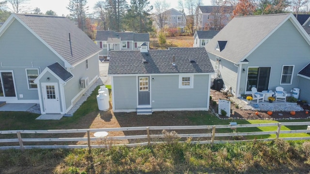 back of property with a residential view and a patio